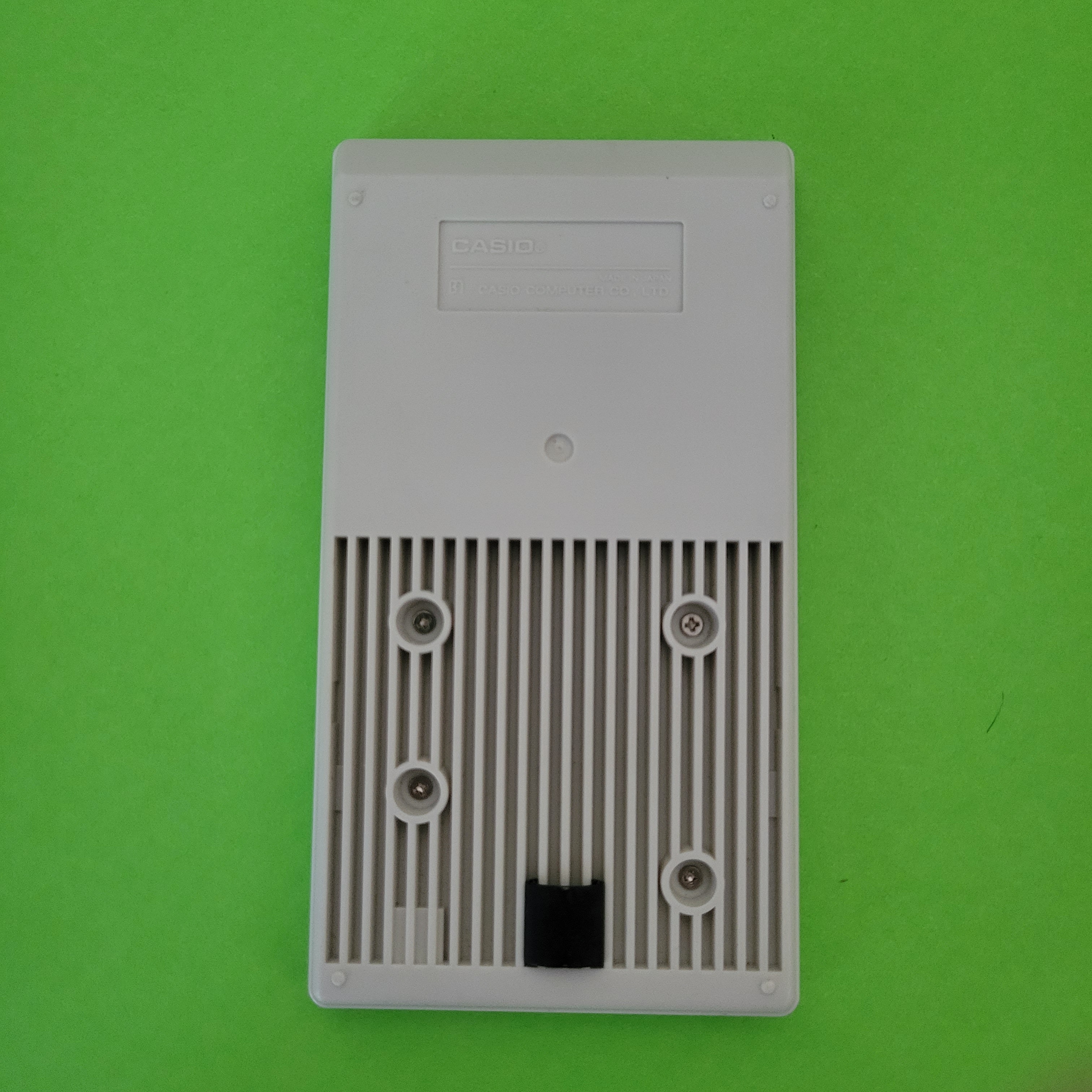 An image of the back of a Casio HS-8 Four Function + calculator